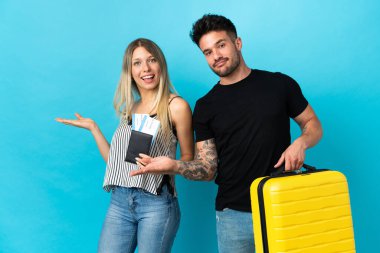 Kafkasyalı genç çift mavi arka planda tek başlarına seyahat edecek. Davet ettikleri için ellerini yana uzatacaklar.