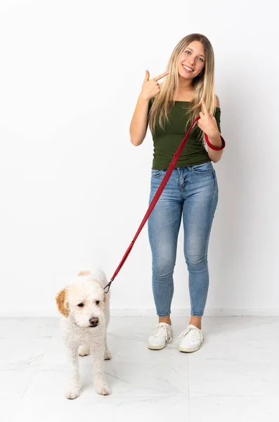 Молодая Белая Женщина Выгуливает Собаку Белом Фоне Показывая Большой Палец — стоковое фото