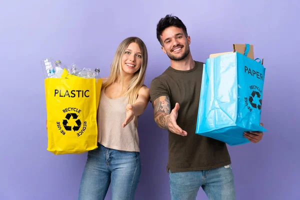 Jovem Caucasiano Casal Reciclagem Isolado Roxo Fundo Apertando Mãos Para — Fotografia de Stock