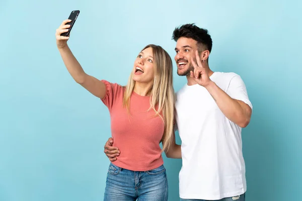 Jovem Casal Caucasiano Isolado Fundo Azul Fazendo Uma Selfie Com — Fotografia de Stock