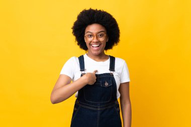 Sarı arka planda yüzü şaşırmış genç Afrikalı Amerikalı kadın.