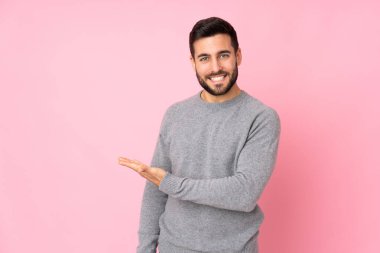 Kafkasyalı yakışıklı adam soyutlanmış bir arka planda gülümserken bir fikir sunuyor.