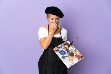 Mor arka planda izole edilmiş bir palet tutan genç Rus kadın şüphe duyuyor.