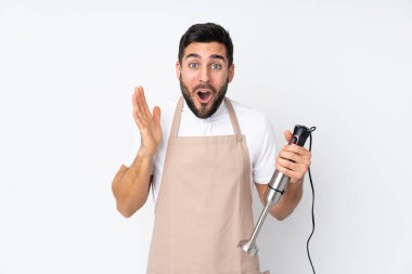 El blenderi kullanan adam beyaz arkaplanda izole edilmiş ve yüz ifadesi şaşırtıcıydı.