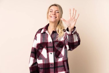 Sarışın kadın izole edilmiş arka planda beş parmaklı sayıyor.