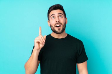 Beyaz tenli yakışıklı adam mavi arka planda izole edilmiş.