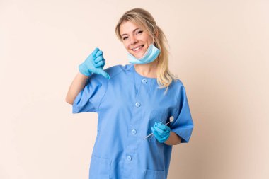 Dişçi kadın kendini beğenmiş ve gururlu arka planda aletler tutuyor.