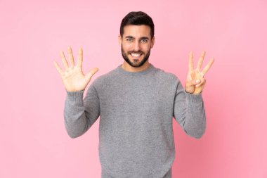 Kafkas yakışıklı adam tecrit edilmiş arka planda sekiz parmaklı sayıyor.