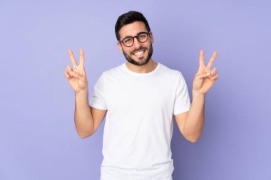 Kafkasyalı yakışıklı adam izole edilmiş arka planda iki eliyle zafer işareti gösteriyor.