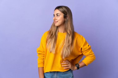 İzole edilmiş mor arka plan görünümlü genç İspanyol kadın.