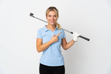 Beyaz arka planda izole edilmiş genç bir Rus golfçü kadın bir ürün sunmak için kenarı işaret ediyor.