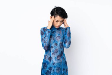 Kısa saçlı genç Vietnamlı kadın geleneksel bir elbise giyiyor izole edilmiş beyaz arka planı ve baş ağrısı var.