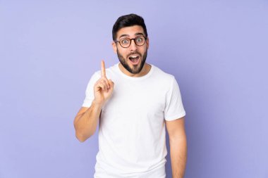 Kafkasyalı yakışıklı adam izole edilmiş arka planda çözümü bulmak için parmağını kaldırıyor.