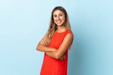 Kollarını kavuşturup ileriye bakan, soyutlanmış mavi bir geçmişi olan genç İspanyol kadın.