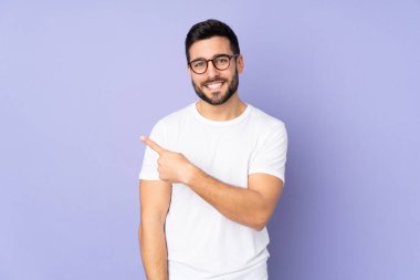 Kafkasyalı yakışıklı, soyutlanmış bir geçmişi olan bir adam bir ürün sunmak için kenarı işaret ediyor.