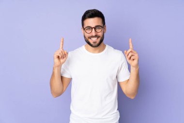 Kafkasyalı yakışıklı adam izole edilmiş arka planda harika bir fikre işaret ediyor.