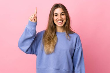 Soyutlanmış pembe arka planı olan genç bir kadın harika bir fikri işaret ediyor.