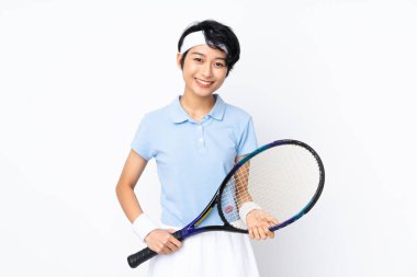 Tenis oynayan genç Vietnamlı tenisçi kadın izole edilmiş beyaz duvarın üzerinde