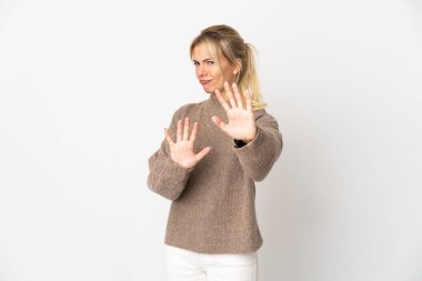 Beyaz arka planda izole edilmiş genç bir Rus kadın gergin bir şekilde ellerini öne uzatıyor.