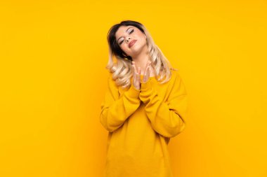 Sarı arka planda izole edilmiş genç kız bir konferansta sunumdan sonra alkışlıyor.