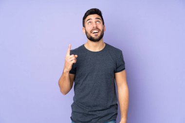 Kafkasyalı yakışıklı adam, mor arka planda yalnız kalıp şaşırdı.