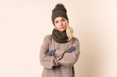 Kışlık şapkalı genç bir kadın izole bir geçmişi var kollarını kavuşturuyor