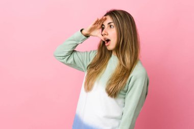 Soyutlanmış pembe arka planı olan genç bir kadın.