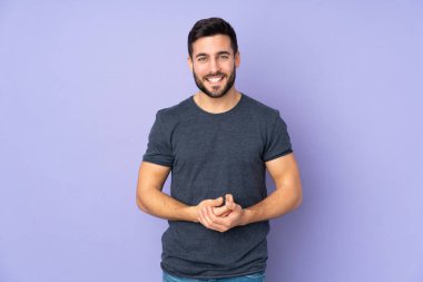 Kafkasyalı yakışıklı adam soyutlanmış mor arka planda gülüyor.