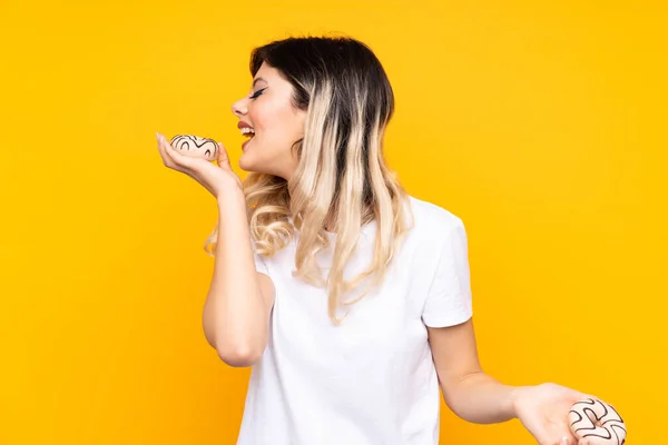 Adolescente Menina Isolada Fundo Amarelo Segurando Donuts Com Expressão Feliz — Fotografia de Stock
