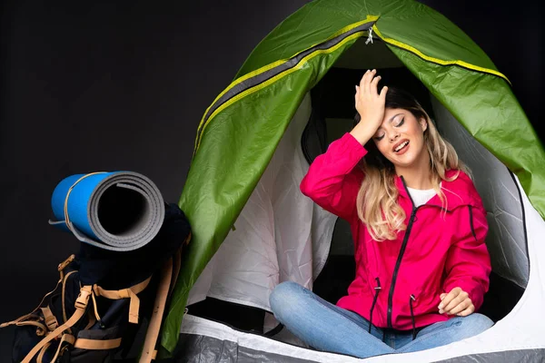 Teenager girl inside a camping green tent isolated on black background has realized something and intending the solution