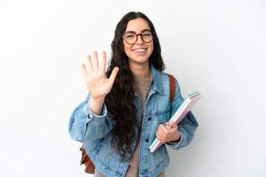 Beyaz arka planda izole edilmiş genç bayan parmaklarıyla beşi sayıyor.