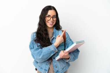 Beyaz arka planda izole edilmiş genç bayan bir ürünü sunmak için kenarı işaret ediyor.