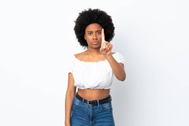 Beyaz arka planda izole edilmiş genç Afrikalı Amerikalı kadın ciddi bir ifadeye sahip birini sayıyor