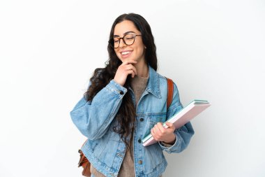 Beyaz arka planda izole edilmiş genç bir bayan. Yan tarafa bakıyor ve gülümsüyor.