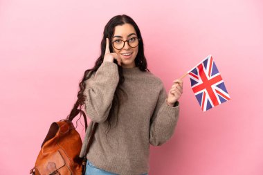 Pembe arka planda Birleşik Krallık bayrağı taşıyan beyaz bir kadın bir fikir düşünüyor.