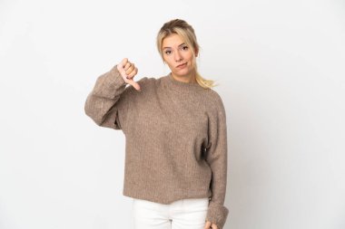 Beyaz arka planda izole edilmiş genç bir Rus kadın başparmağının olumsuz ifadesini gösteriyor.