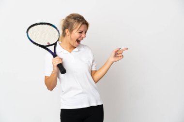 Beyaz arka planda izole edilmiş genç Rus tenisçi parmağını yana doğru uzattı ve bir ürün sundu.