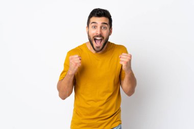 Beyaz arka planda sakallı yakışıklı genç adam zaferi kutluyor.