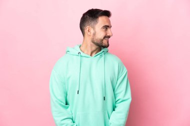 Pembe arka planda soyutlanmış beyaz, yakışıklı bir adam.