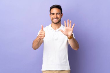 Mor arka planda izole edilmiş genç ve yakışıklı bir adam.