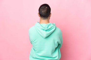 Pembe arka planda izole edilmiş beyaz, yakışıklı genç bir adam.