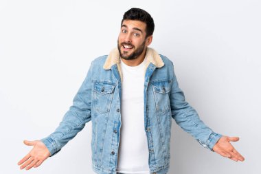 Beyaz arka planda sakallı yakışıklı genç adam mutlu ve gülümsüyor.