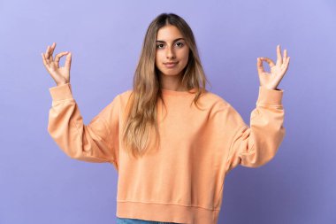 Zen pozisyonunda, soyutlanmış mor bir geçmişi olan genç İspanyol kadın.