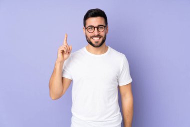 Kafkasyalı yakışıklı adam izole edilmiş arka planda harika bir fikre işaret ediyor.