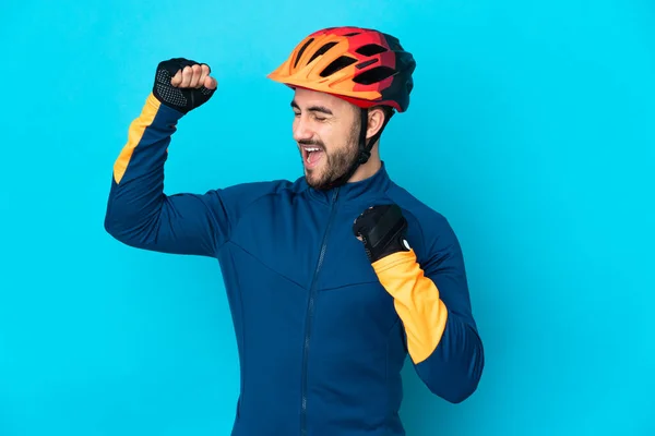 Joven Ciclista Aislado Sobre Fondo Azul Celebrando Una Victoria — Foto de Stock