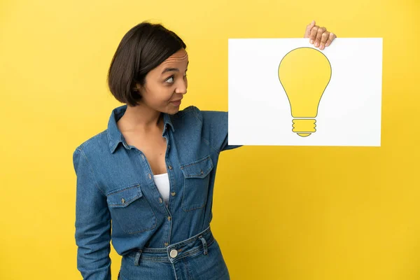 Young Mixed Race Woman Isolated Yellow Background Holding Placard Bulb — Stock Photo, Image