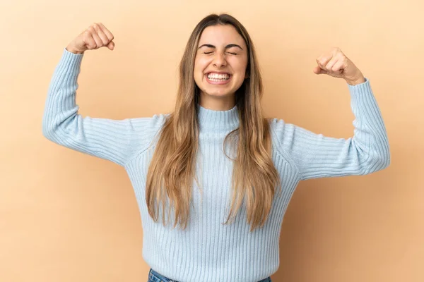 Jonge Kaukasische Vrouw Geïsoleerd Beige Achtergrond Doen Sterke Gebaar — Stockfoto