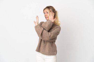 Beyaz arka planda izole edilmiş genç bir Rus kadın gergin bir şekilde ellerini öne uzatıyor.