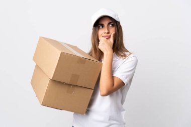 Genç teslimatçı kadın izole edilmiş beyaz arka planda kuşkuları var ve kafası karışmış bir yüz ifadesi var.