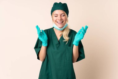 Yeşil üniformalı kadın izole arka planda gülüyor.